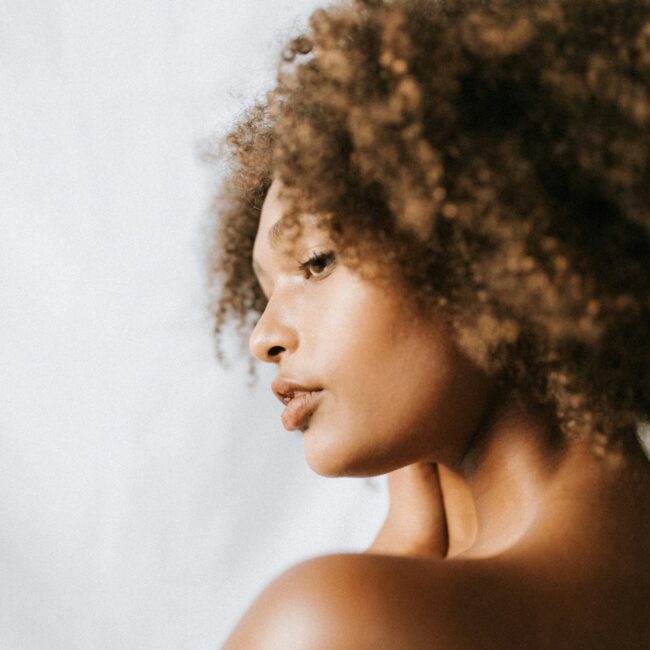 Femme avec une afro de profil touchant ses cheveux